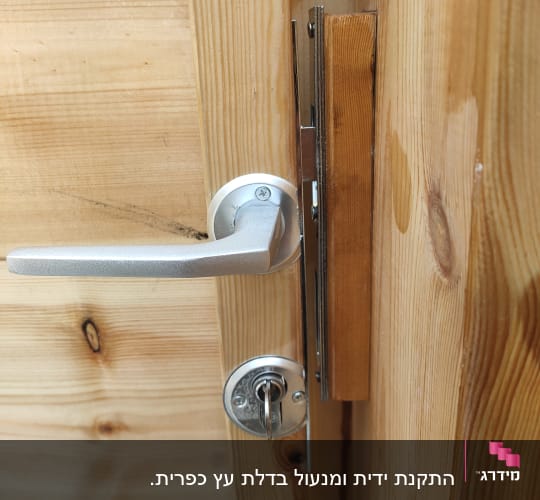 צילינדר מנעול וידית מותקנים על דלת עץ עם תיקון משקוף
